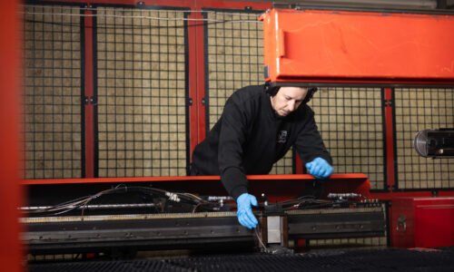 operator checking CNC punch machine prior to metal punching services