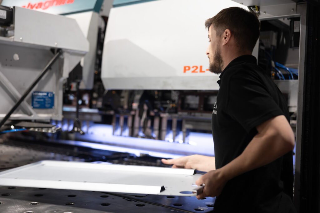 Utilising Unifabs' metal forming services an operator unloads part from Salvagnini automated panel bending machine