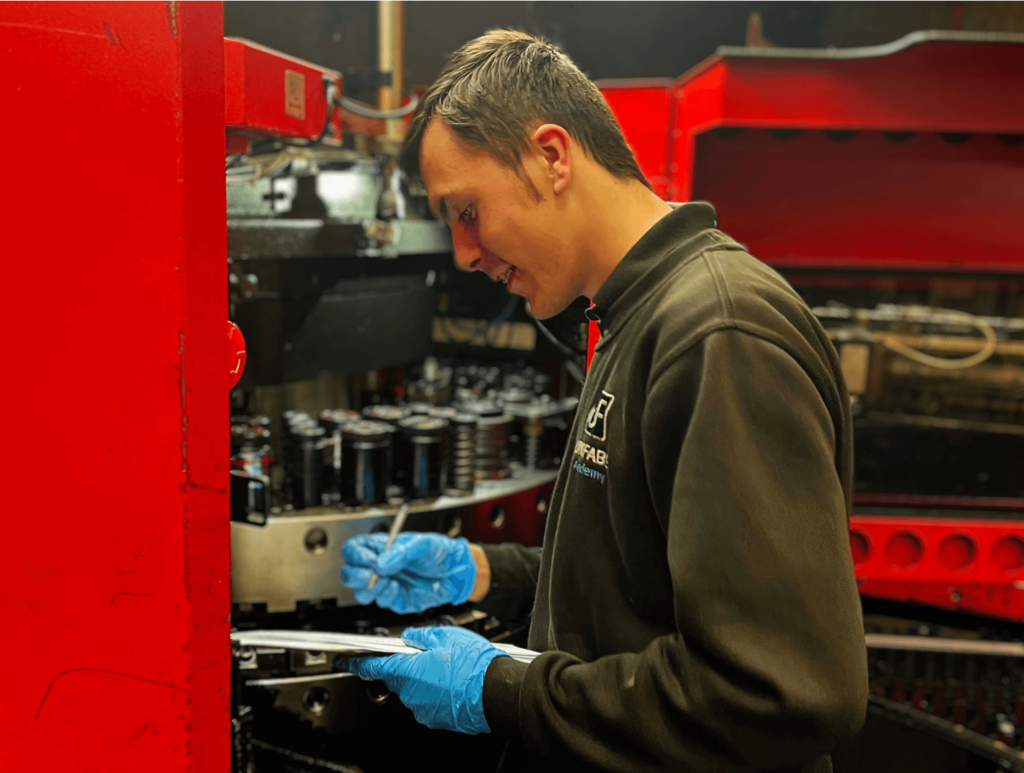 Apprentice preforming a tool change on the punch machine