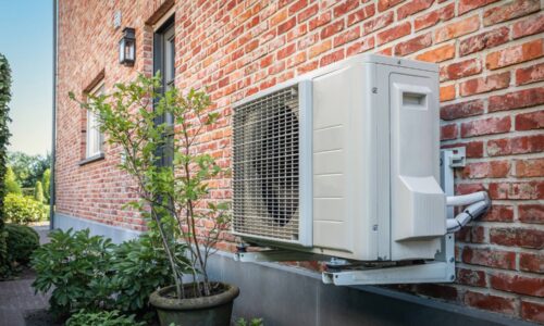 heat pump installed on the side of a brick building demonstrating sheet metal components for white goods