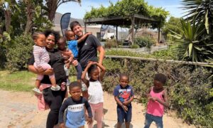 Jason Austin, Unifabs Chief Executive, with Trina and children from Siyakhula Nursery